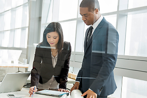 Two people reviewing work at a table